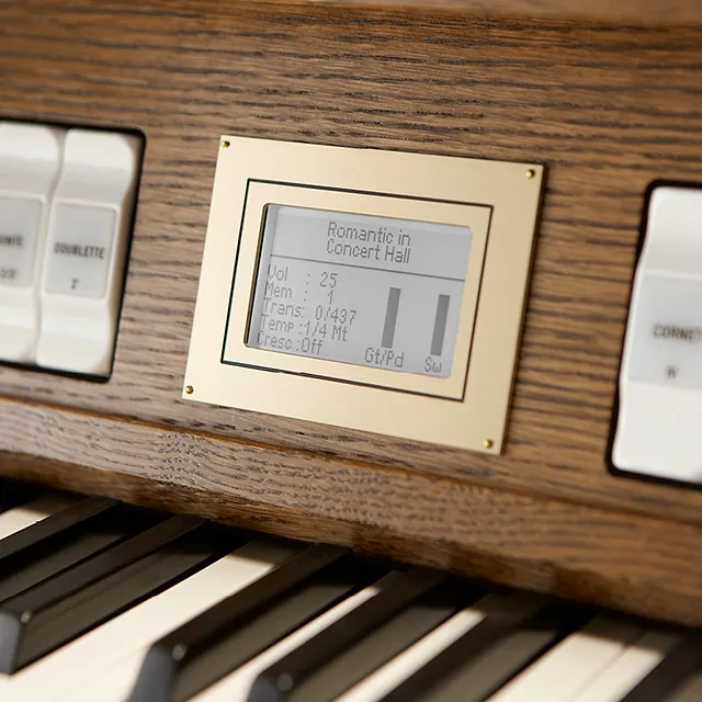 Nærbilde av et kirkeorgel-tangentbord med knapper, knotter og en digital skjerm for forbedret musikalsk kontroll.